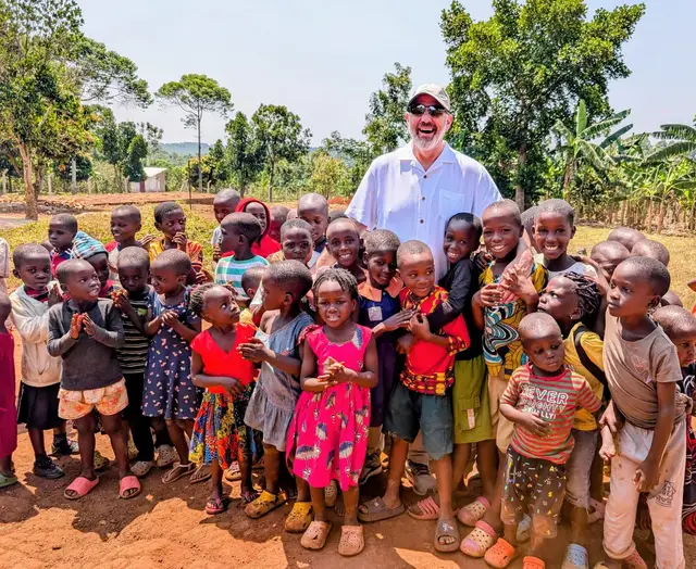 Jeff Hoffman standing with a large group of children outdoors